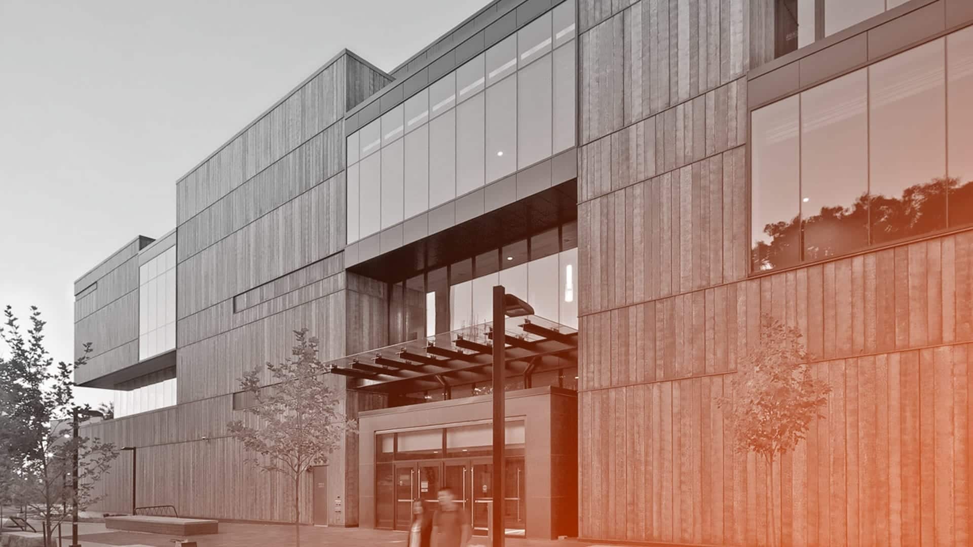 Students walking at dawn amidst the blue copper facade of the Instructional Centre.