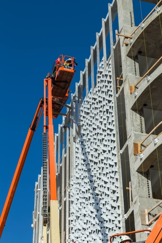 Photo of installers hanging wrapped panels for the Leong Leong facade