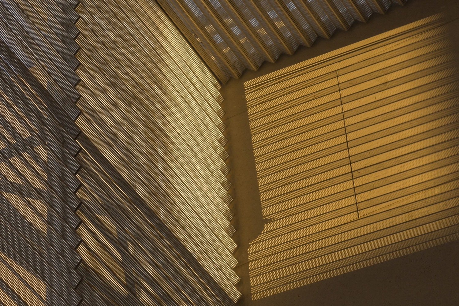 Detail of the argyle shadows cast by folded metal with perforations.
