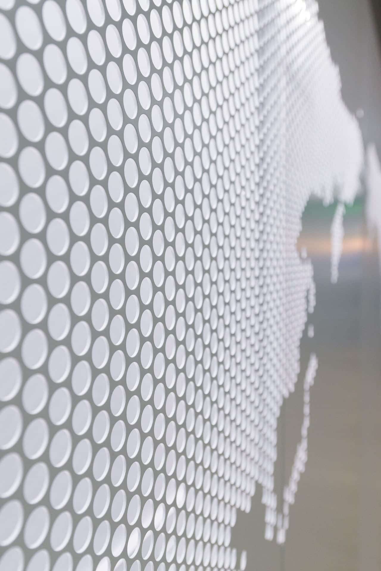 Detail of the perforated metal, painted grey on its exterior and white on its interior.