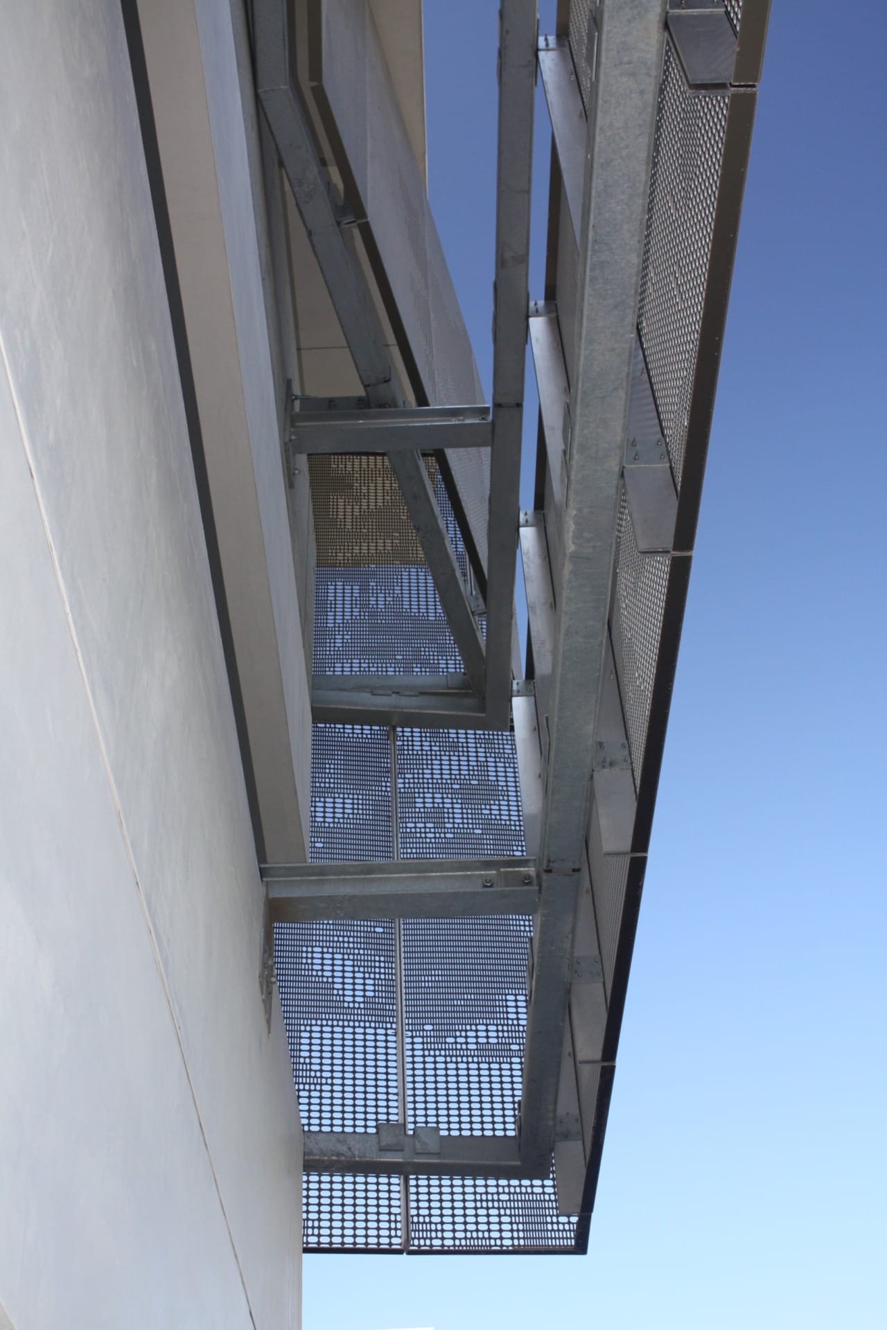 Detail of the perforated zigzag aluminum system used to cool and ventilate the school's parking garage. 