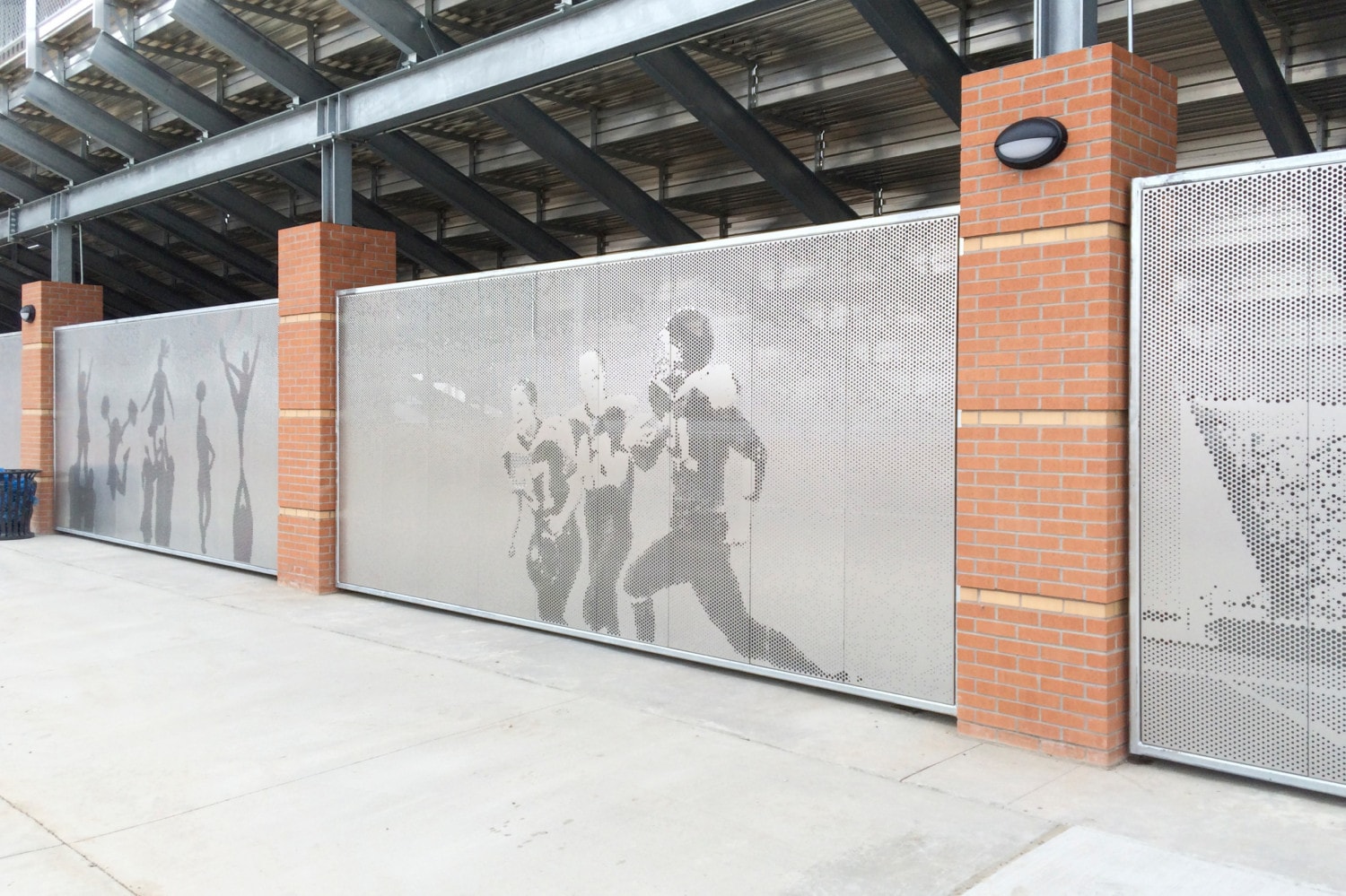 Perforated metal screen wall prevents access to under bleachers without drawing attention to its inherent security.