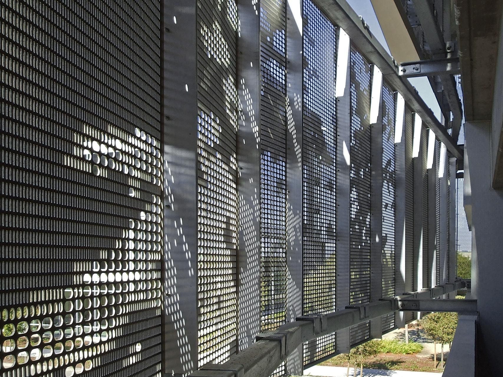 Detail of the undulating facade design by WRNS Studio with custom oval perforation design.