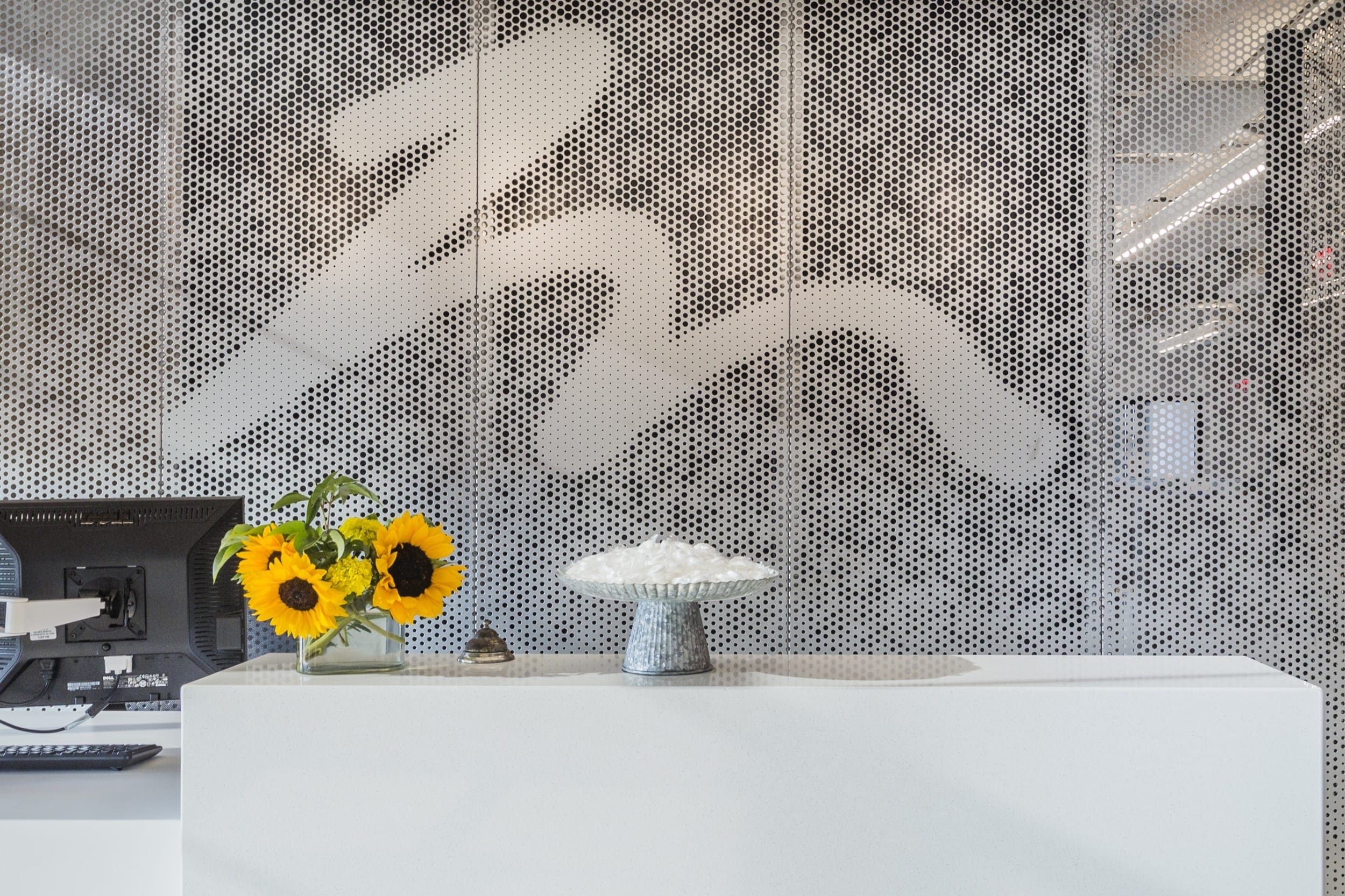 Free-standing screen in Angel Hair Stainless Steel with a painted aluminum backing for office lobby.