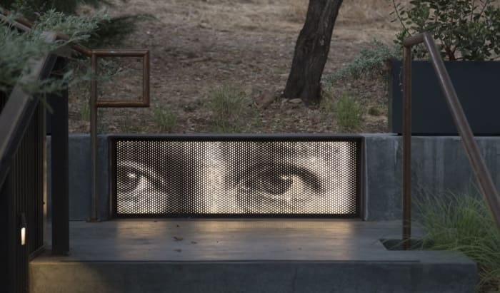 Backlit, finely perforated painted aluminum panel which forms the front of a metal seat.