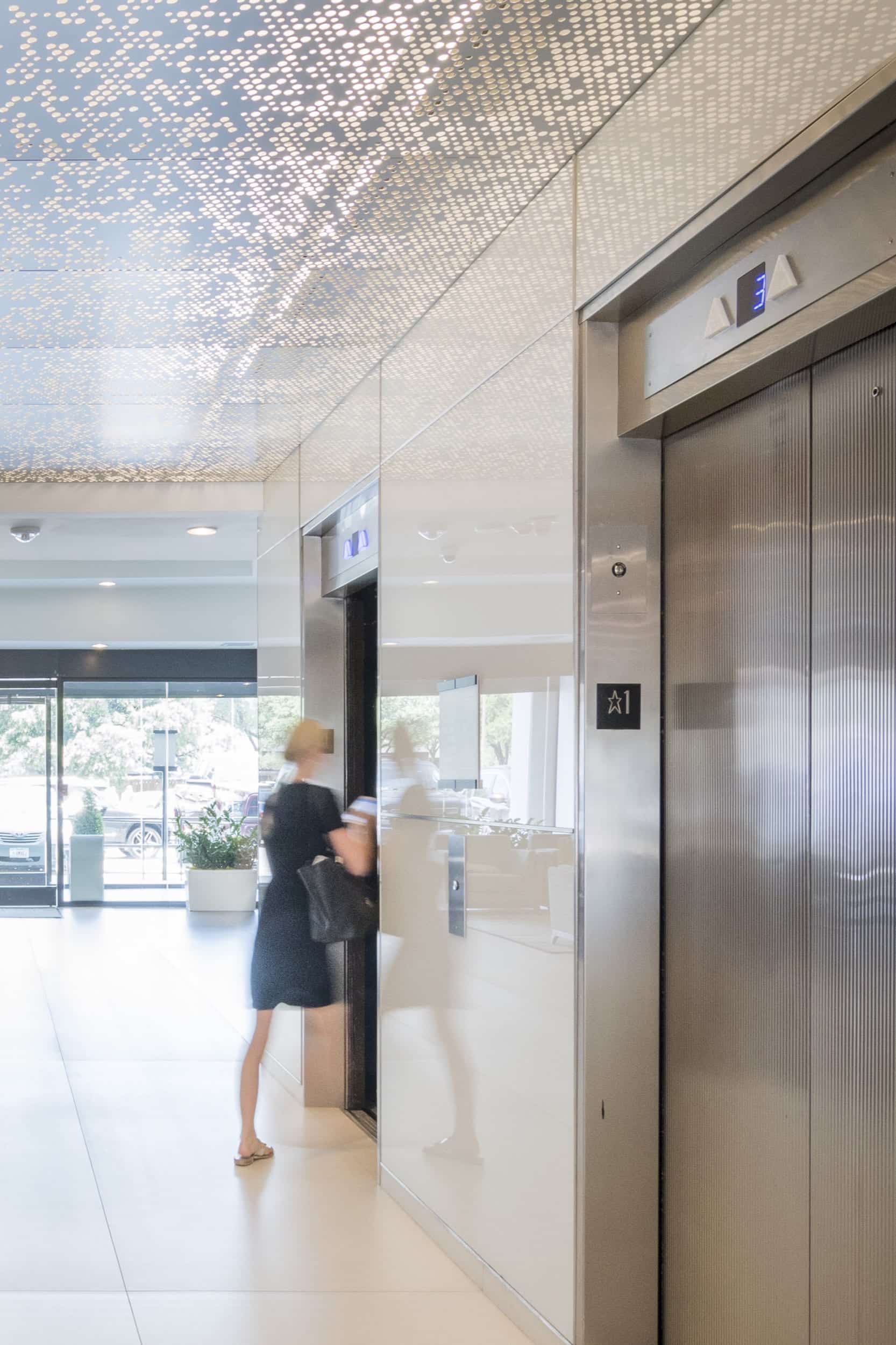 Woman enters an elevator below an ImageWall ceiling.