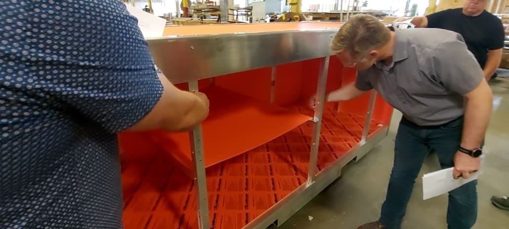 Winning crate design judging Judges inspect a mock-up of the winning crate design made of aluminum and high-density polyethylene.