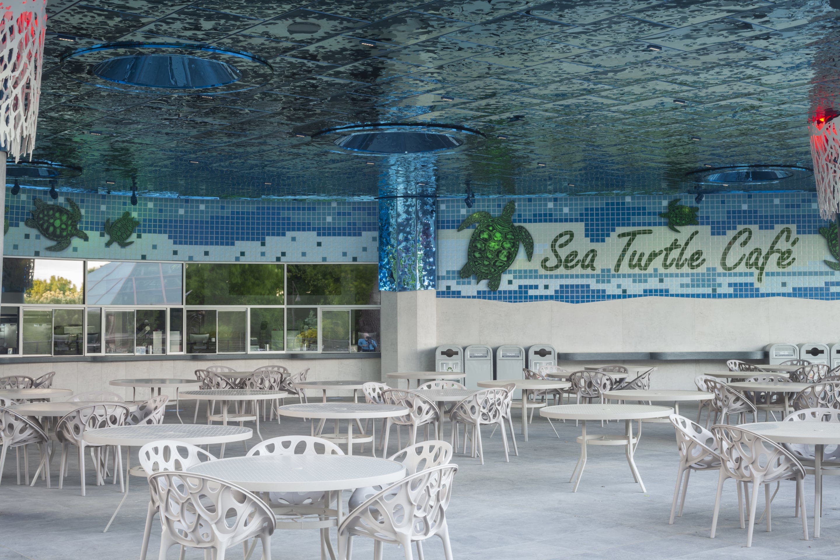 Custom rippled blue stainless steel clads the ceiling of the outdoor cafe to create an underwater feel to the space.