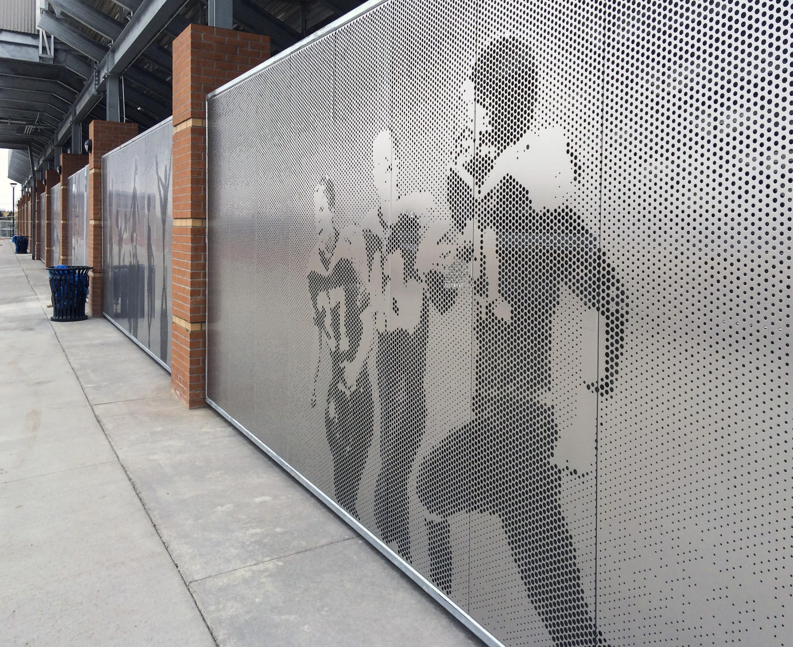 Custom screen walls emphasize a sports theme for Okie Blanchard Sports Complex while also functioning as passive security measures that prevent access under the bleachers.