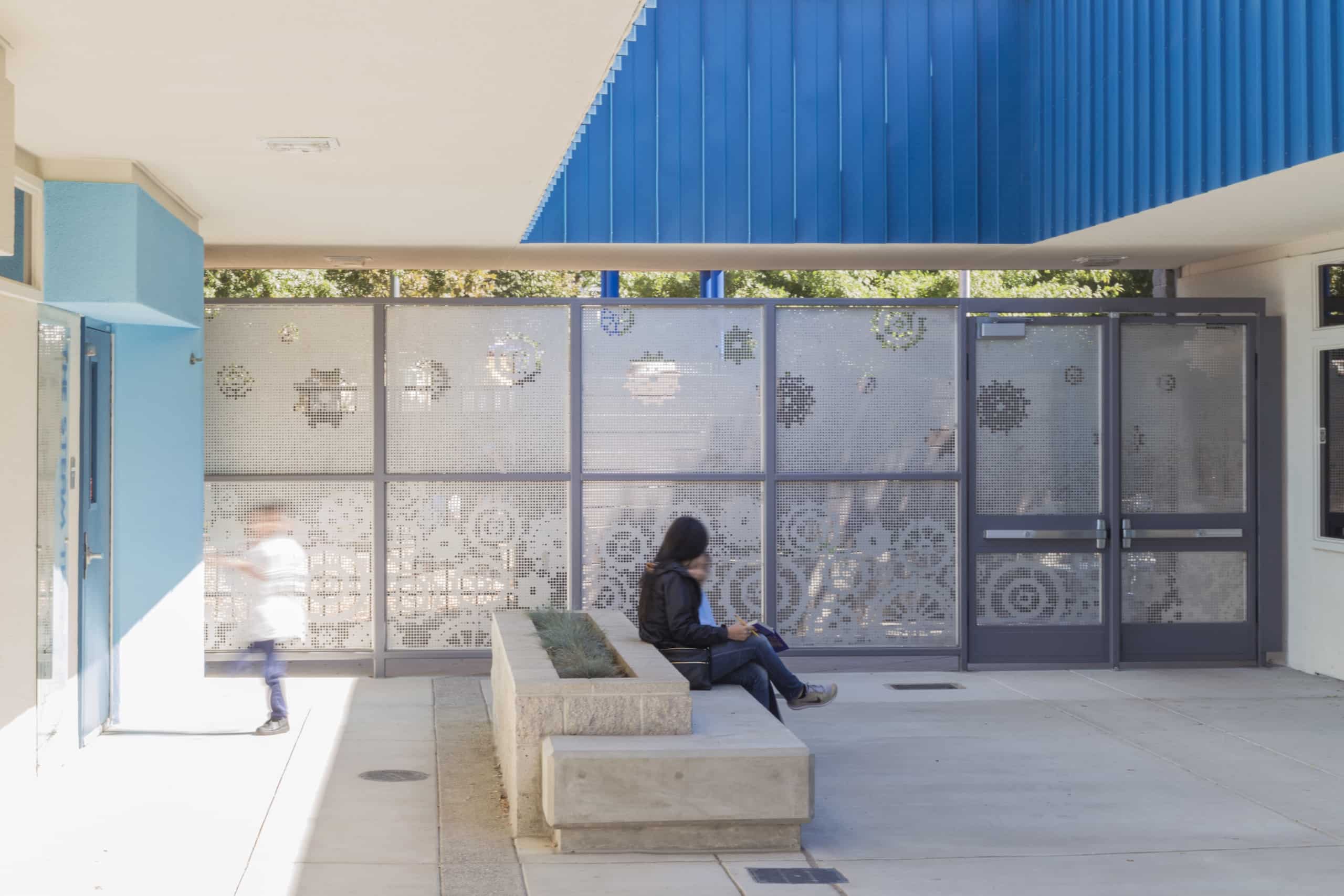 A perforated metal screen wall creates a private space for the courtyard at Washington Elementary.