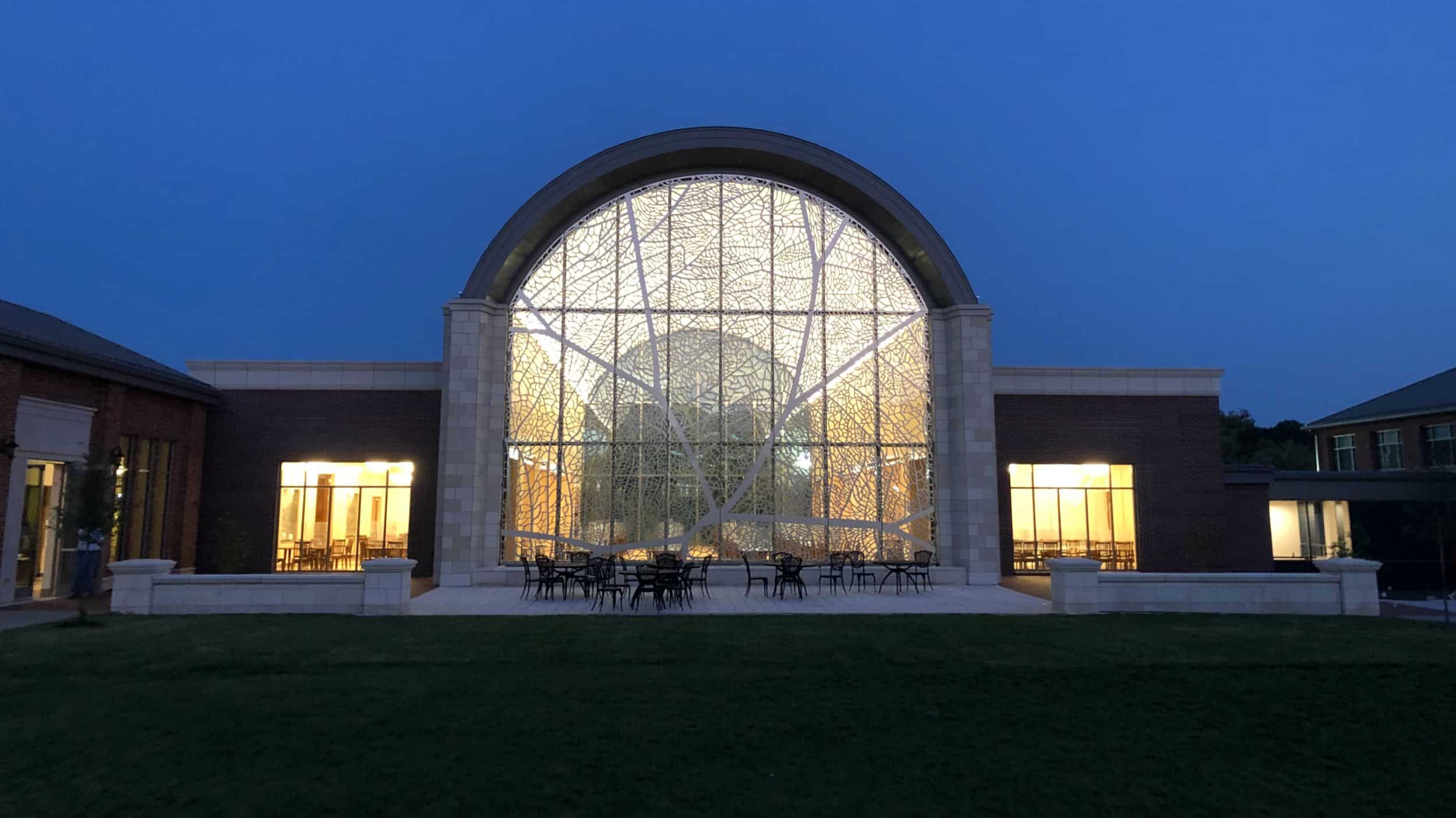 A nighttime view of Pembroke Hill preparatory school's barrel-vaulted dining hall, which features artwork by Dutch artist Jan Hendrix, fabricated by Zahner.