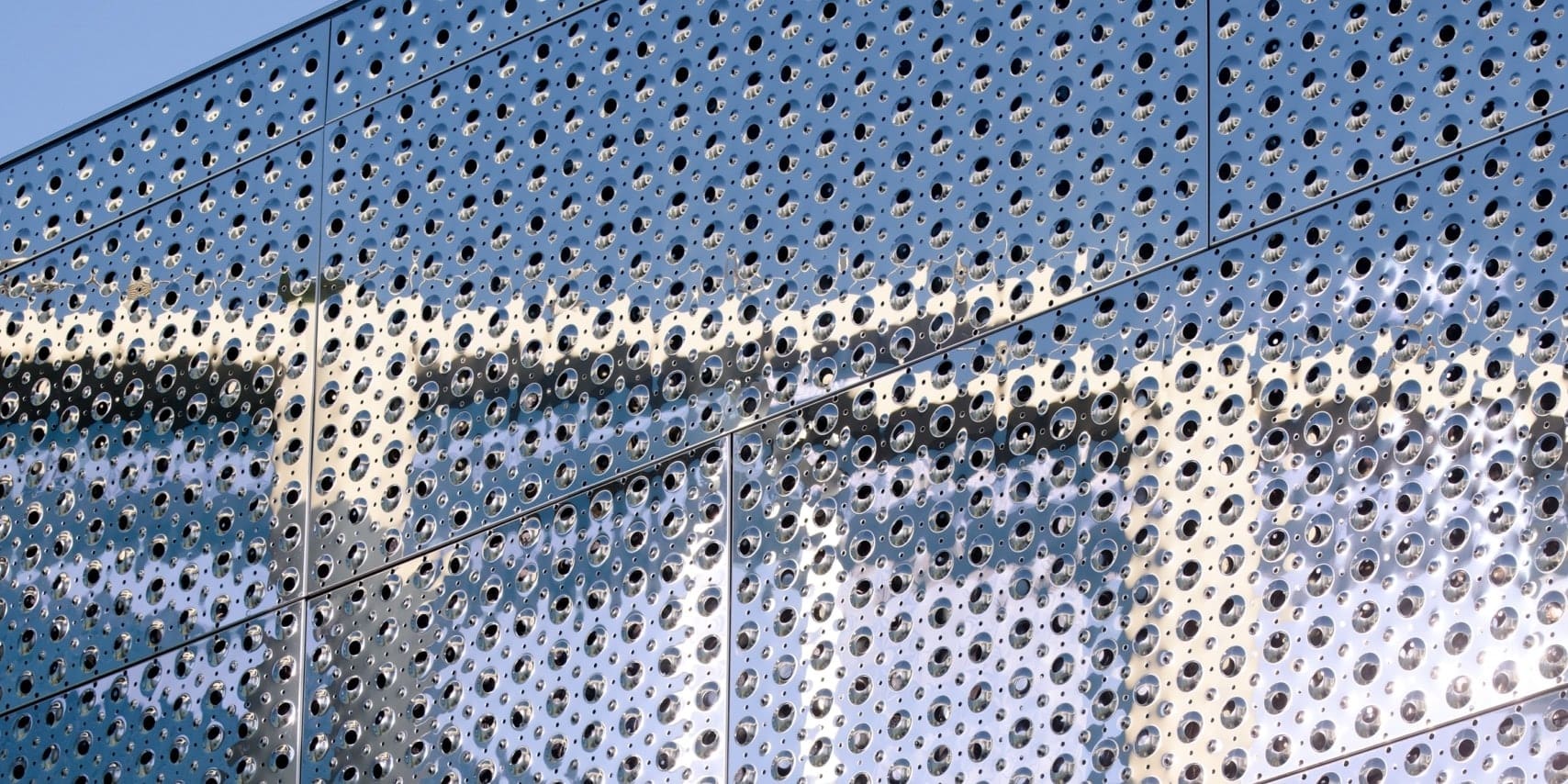 Detail of the custom perforated emboss used to bump and perf the stainless steel facade of Harim Tower.