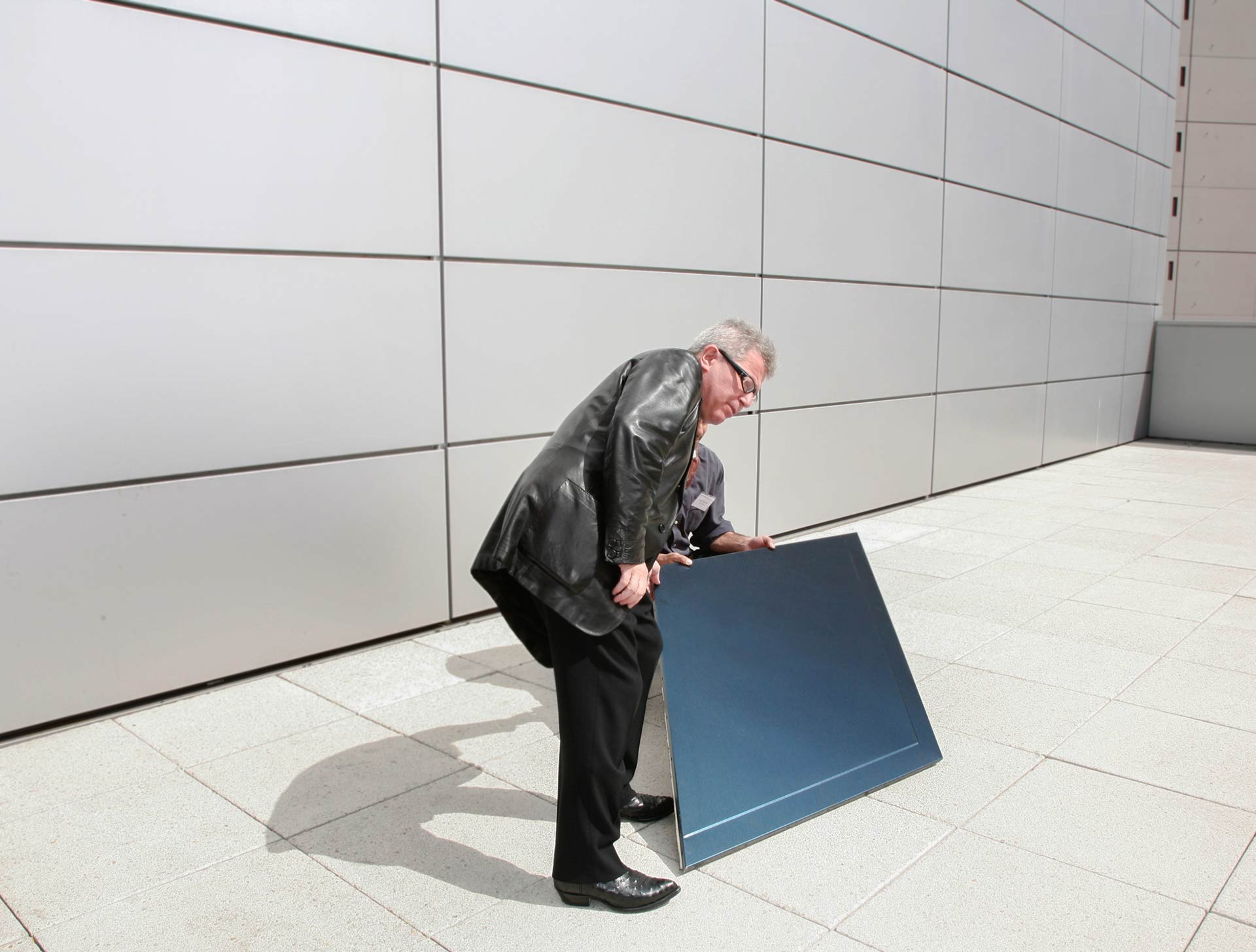 DANIEL LIBESKIND EXAMINES THE LIGHT REFLECTIVITY OF ONE OF ZAHNER'S PANELS AT THE CONTEMPORARY JEWISH MUSEUM IN SAN FRANCISCO.
