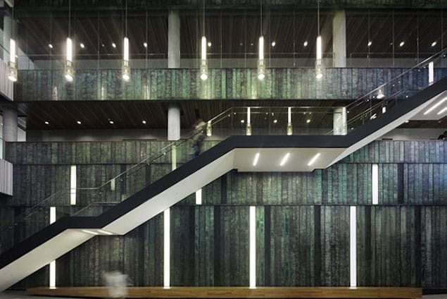 wide-main-stair-lisa-logan-night THE MOOD OF THE PATINATED COPPER INTERIOR WALLS CHANGES DURING THE EVENING.