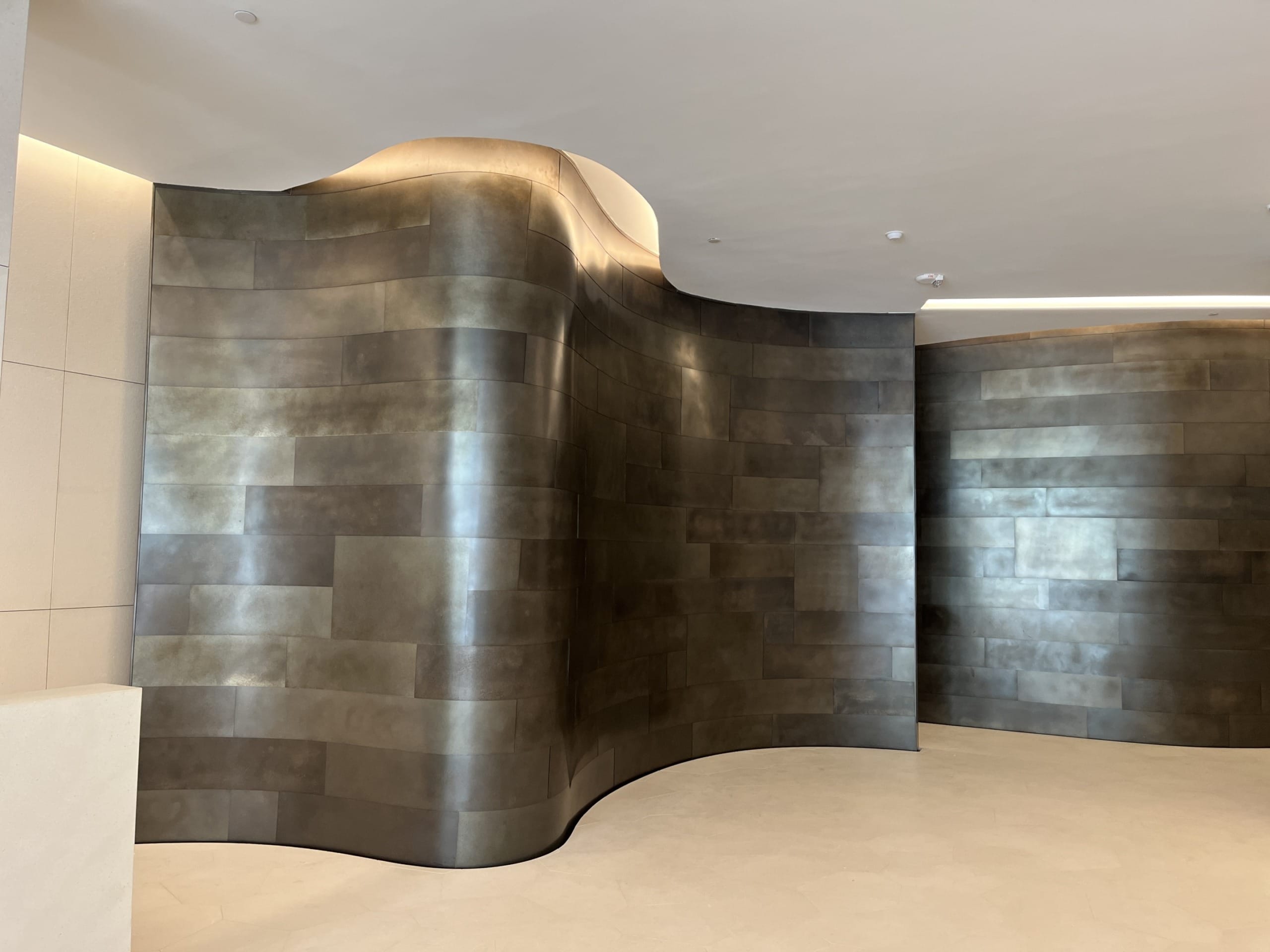 THE STRUCTURE OF THE CURVILINEAR WALLS OF THE LOBBY WAS CREATED WITH ZAHNER'S ENGINEERED PROFILE PANEL SYSTEM (ZEPPS).