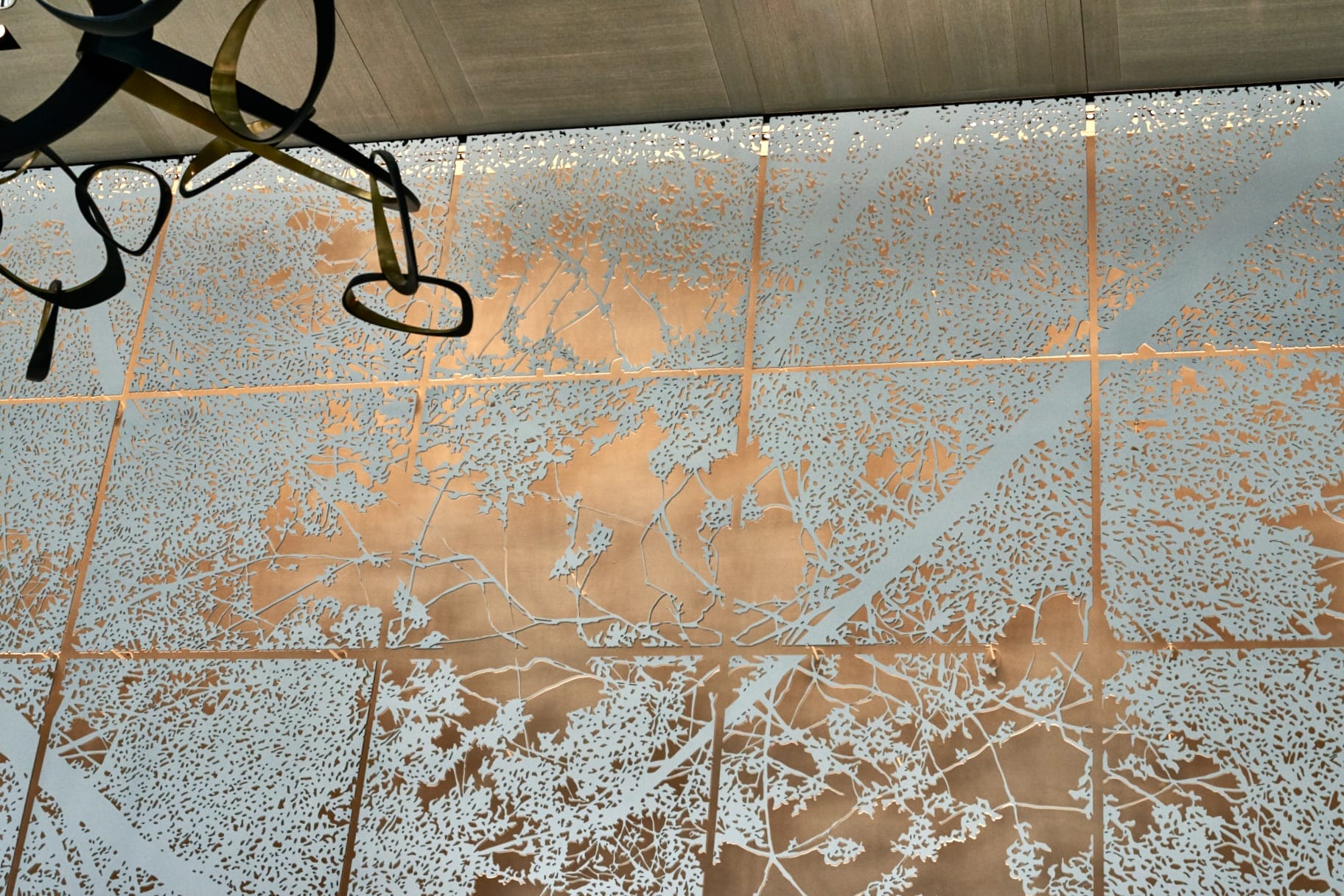 Close up of interior art wall featured in the Embassy Gardens. The image depicts a forest canopy.